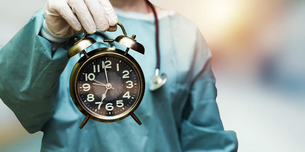 Surgeon holding clock